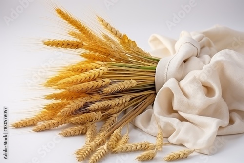 Organic wheat ears and grains bundle on white table, farm harvest concept for food background