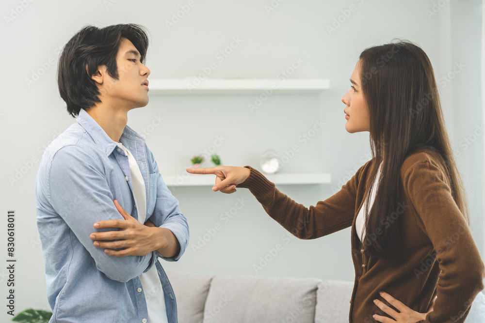 Asian young couple fight standing on white background, relationship in trouble. Different angry, use emotion shouting at each other. Argue husband has expression of disappointment and upset with wife. Asian young couple fight standing on white background, relationship in trouble. Different angry, use emotion shouting at each other. Argue husband has expression of disappointment and upset with wife.