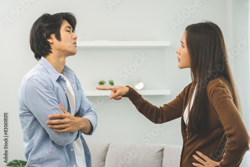 Asian young couple fight standing on white background, relationship in trouble. Different angry, use emotion shouting at each other. Argue husband has expression of disappointment and upset with wife. © KMPZZZ
