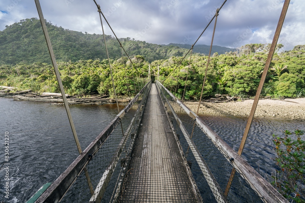 Fototapeta premium Hiking trail bridge crossing the Kohaihai River on Heaphy Track, Karamea, West Coast, New Zealand.