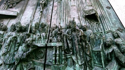 close up of holy religious men depicted on bronze church door of Catedral De La Almudena in Madrid photo