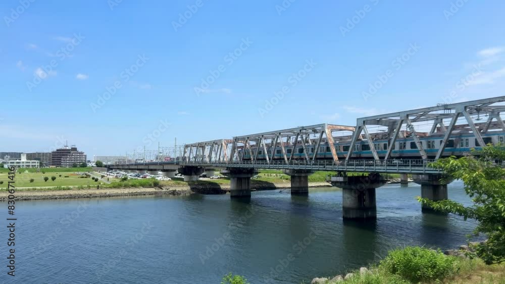 Steel bridge over a river on a sunny day with cityscape in the background Steel bridge over a river on a sunny day with cityscape in the background