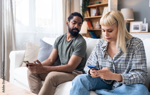 Young couple at home have a problem and argue due to jealousy caused by chatting and flirting via social media networks on smart phones, relationship difficulties problems and distrust