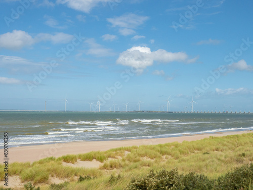 Zeeland, Netherlands - August 2nd 2023: Beautiful beach with sand dunes in front of Oosterscheldekering dam