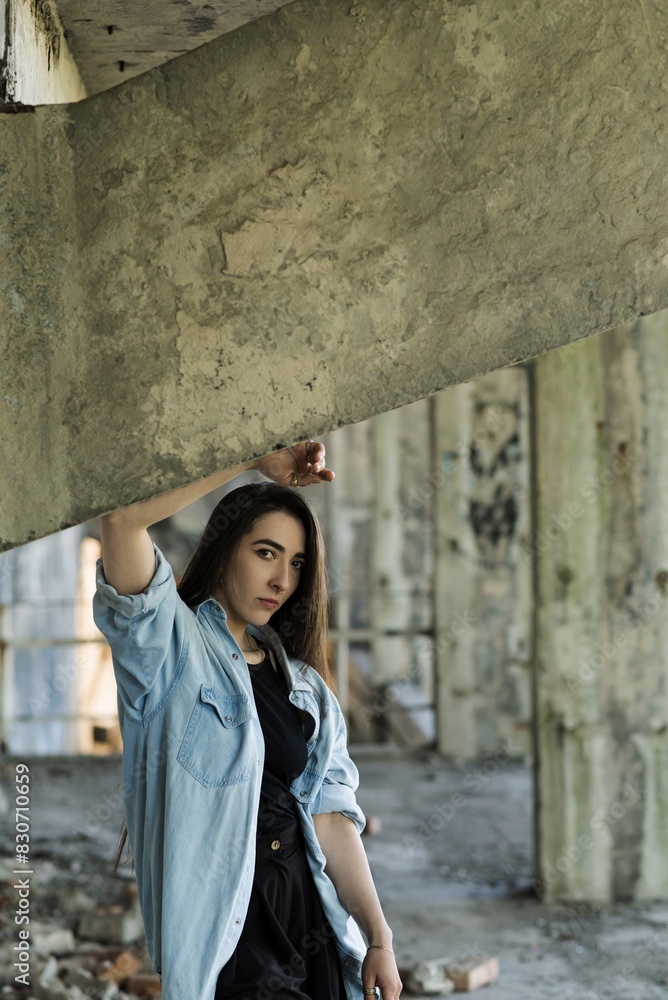 Attractive Caucasian young woman brunette hippie in casual clothes posing on the grounds of an abandoned building while walking on a warm spring day. Style, Fashion, Freedom. Attractive Caucasian young woman brunette hippie in casual clothes posing on the grounds of an abandoned building while walking on a warm spring day. Style, Fashion, Freedom.