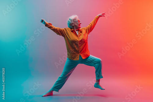 Joyful senior woman dancing in vivid colors