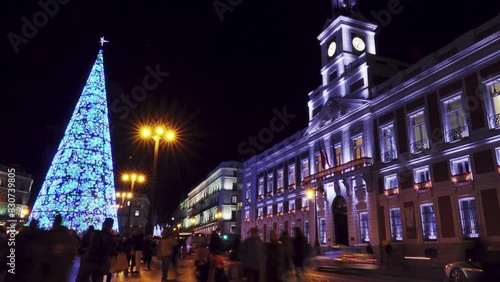 MADRID, SPAIN - DECEMBER 4 2017: Christmas tree on Puerta del Sol (Gate of Sun), is public square in Madrid, Spain, one of best known and busiest places in city. Square also contains the famous clock.
