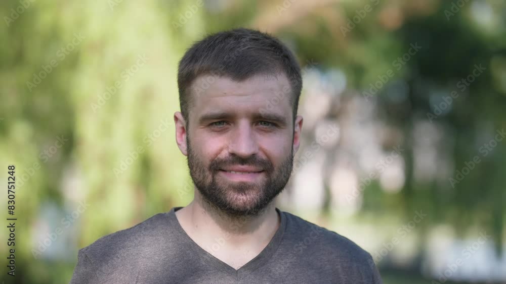Summer portrait of a handsome man with a beard in the park slow motion Summer portrait of a handsome man with a beard in the park slow motion