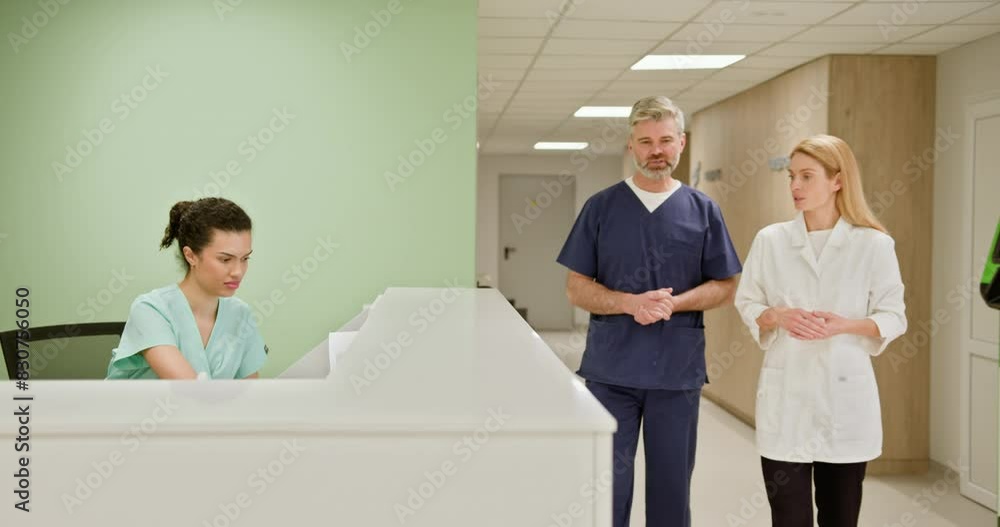 Group of medical staff at a hospital reception desk collaborating and ...