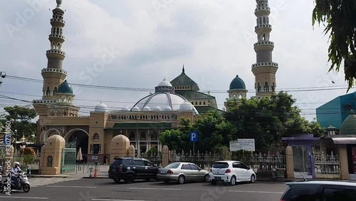 Purbalingga, Indonesia - 28 May 2024: the atmosphere in front of the Darussalam Grand Mosque in Purbalingga with an asphalt road where motorbikes are running photo