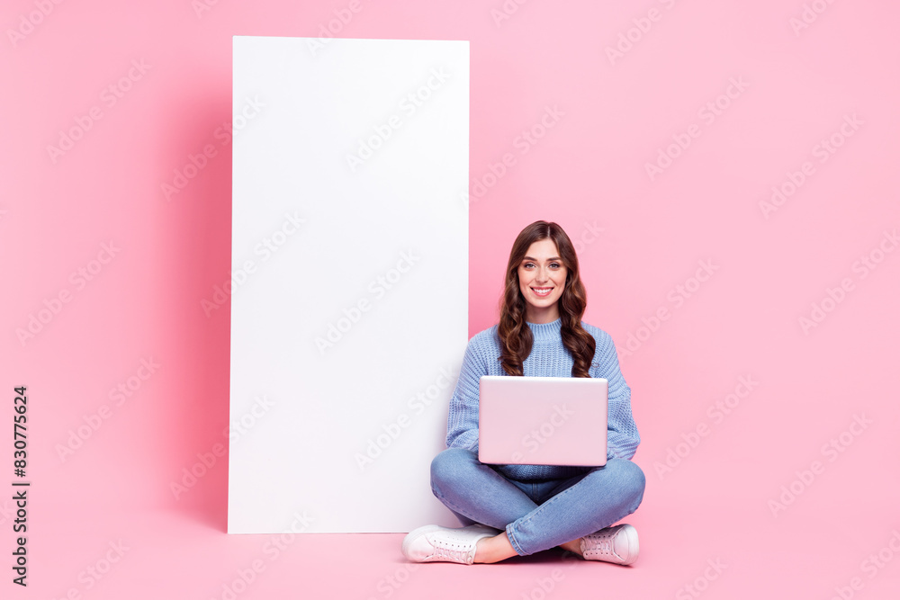 Full size photo of positive nice girl use wireless netbook big empty space banner isolated on pink color background Full size photo of positive nice girl use wireless netbook big empty space banner isolated on pink color background