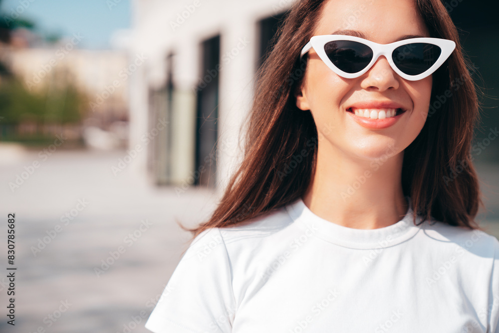 Portrait of young beautiful smiling woman in trendy summer clothes. Sexy carefree woman posing in the street at sunset. Positive model outdoors at sunny day. Cheerful and happy. Closeup, sunglasses Portrait of young beautiful smiling woman in trendy summer clothes. Sexy carefree woman posing in the street at sunset. Positive model outdoors at sunny day. Cheerful and happy. Closeup, sunglasses