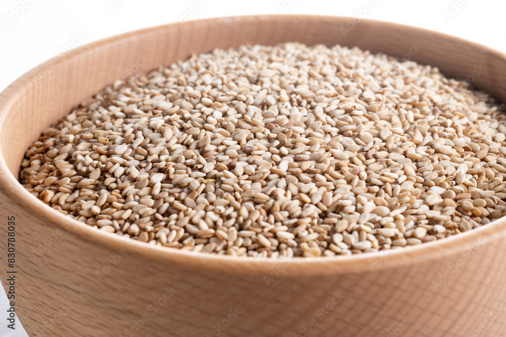 sesame seeds in a wooden bowl isolated on white background. Close up sesame seeds in a wooden bowl isolated on white background. Close up