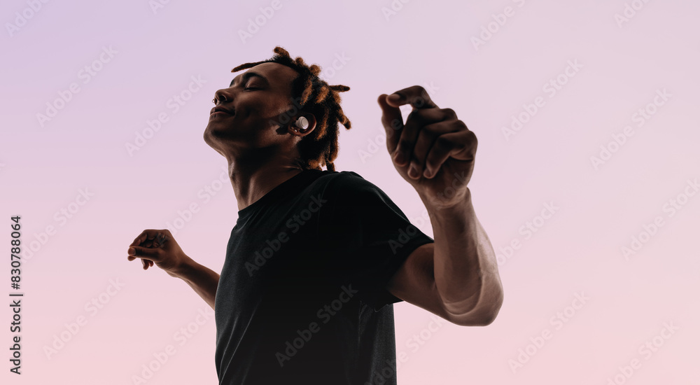 Obraz premium Vibrant dance moves of a young man in silhouette against a pink background