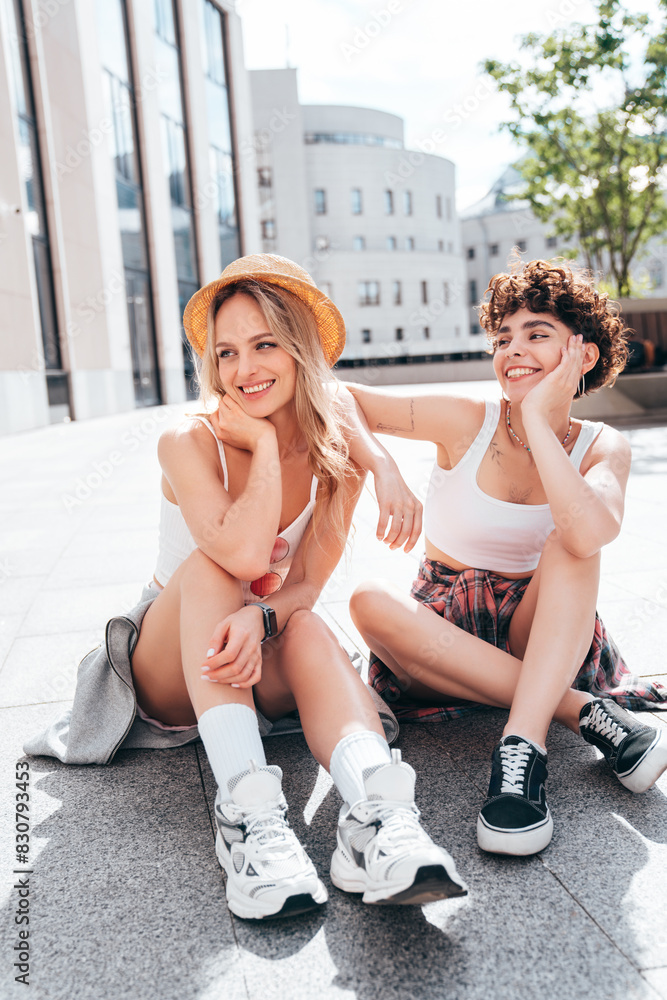 Obraz premium Two young beautiful smiling hipster female in trendy summer white t-shirt and shorts clothes. Sexy carefree women posing in the street. Positive models having fun, hugging and going crazy