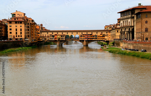 Photo with a view of the Ponte Vecchio arch bridge with houses on it across the Arno river in the historic center of Florence  Tuscany region  Italy
