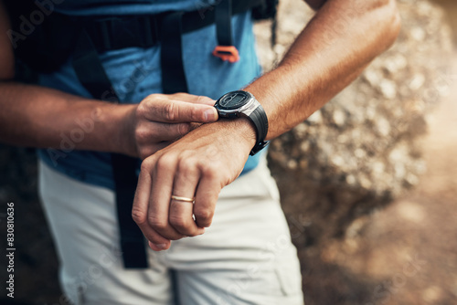 Arms, man and hiking watch in outdoors for fitness with health in mountain nature for exploration. Time, cardio and active hiker with climbing for expedition with travel, stone and trekking in Spain. photo