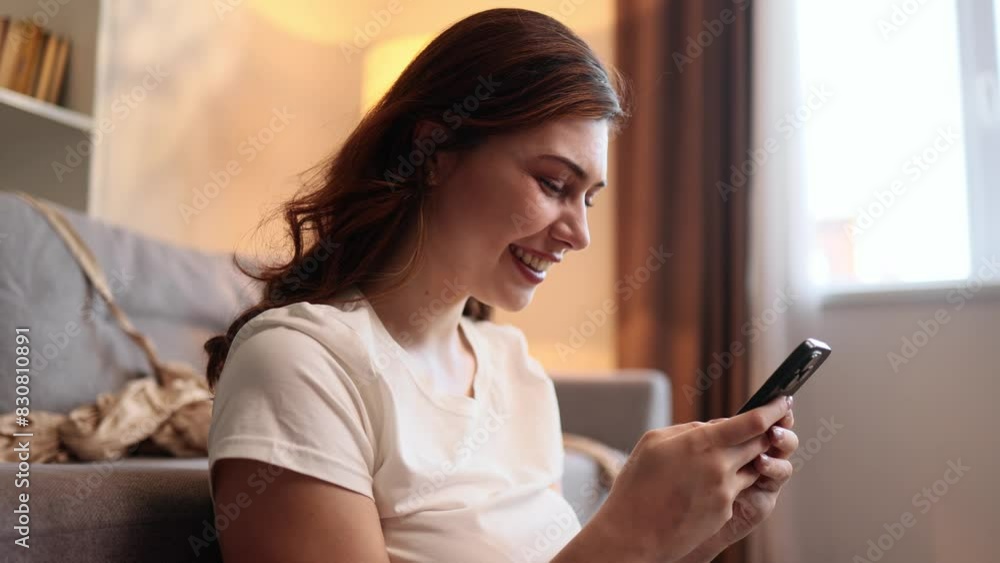 Charming young brunette woman hold smartphone scrolling app watching social media feed fashion app website or internet online store and sitting on clothes at wardrobe at home Charming young brunette woman hold smartphone scrolling app watching social media feed fashion app website or internet online store and sitting on clothes at wardrobe at home