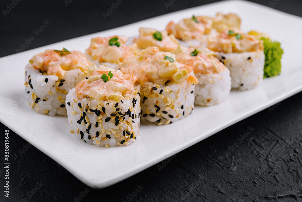Delicious sushi rolls platter on dark background Delicious sushi rolls platter on dark background