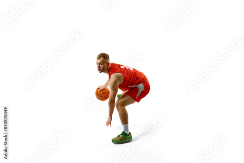 Young man, basketball player playing game, preparing for maneuver or shot against white studio background. Concept of professional sport, games, healthy lifestyle, tournament, action. Ad