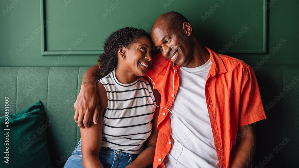 Obraz premium Happy couple sharing a joyful moment on a green sofa
