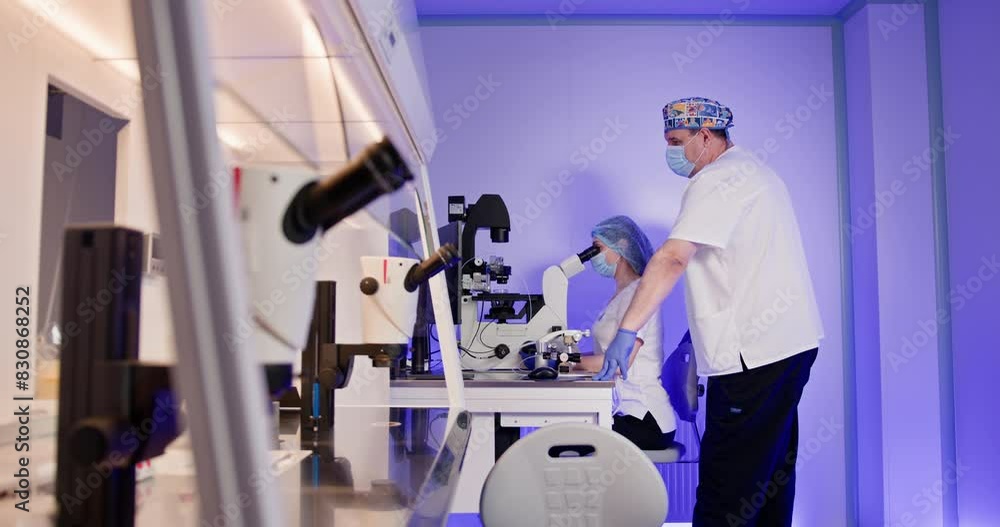 Embryologists performing in vitro fertilization procedures in a modern laboratory setting with specialized equipment. Scientific expertise in reproductive technology. IVF process in action. Embryologists performing in vitro fertilization procedures in a modern laboratory setting with specialized equipment. Scientific expertise in reproductive technology. IVF process in action.