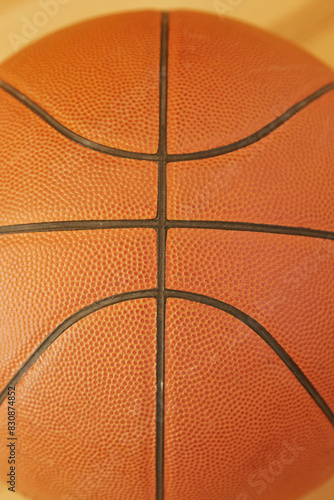 Orange basketball close-up on yellow background, vertical shot, sports background, basketball ball © Александр Ланевский