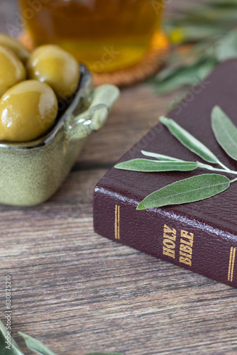 Holy bible book, olive oil and green branch on rustic wooden table. Close-up. Christian biblical concept of anointing, healing, symbol of God's Holy Spirit.