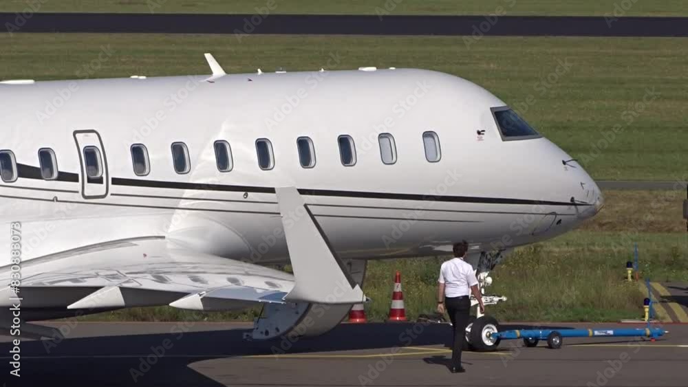 Corporate Jet with PIlot walking next to Aircraft at regional airport (white unmarked Business jet private jet executive jet) Corporate Jet with PIlot walking next to Aircraft at regional airport (white unmarked Business jet private jet executive jet)