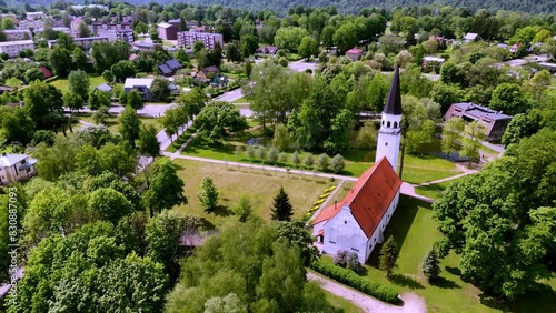 Latvia, Europe -  Panorama of the Sigulda Evangelical Lutheran Church Nestled in the Heart of a Lush Green Park - Aerial Drone Shot photo