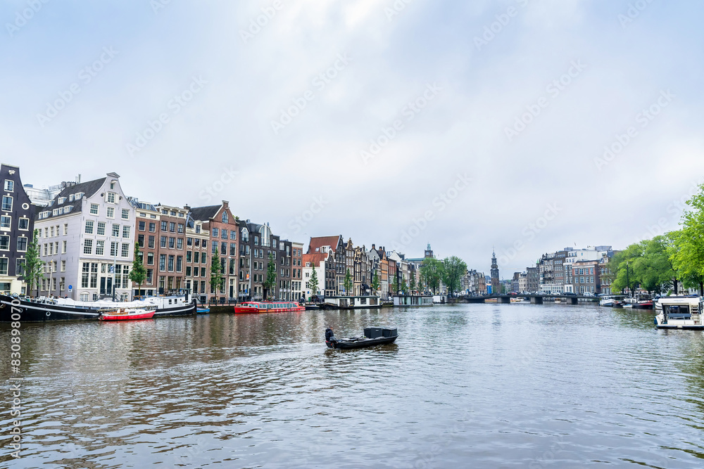 Fototapeta premium Day view in Amstel, Amsterdam, Netherlands with canal and typical Dutch houses.