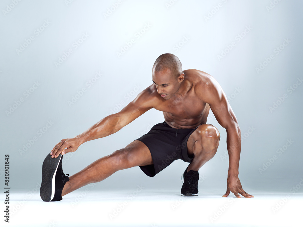 Man, legs and stretching for training in studio for balance, exercise and calf muscle by white background. African person, bodybuilder and warm up on floor for fitness, workout and transformation Man, legs and stretching for training in studio for balance, exercise and calf muscle by white background. African person, bodybuilder and warm up on floor for fitness, workout and transformation
