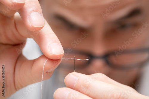 針に糸を通す男性 photo