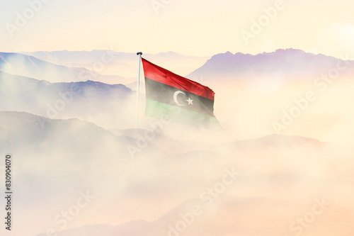 Libya flag disappears in beautiful clouds with fog. photo
