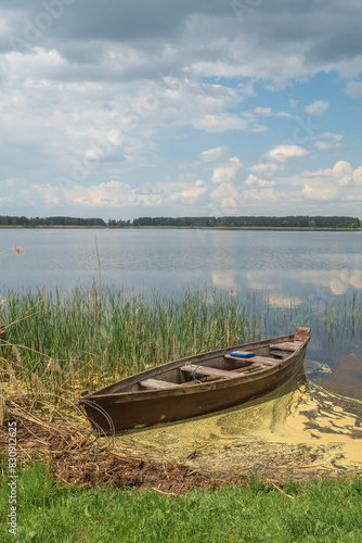old wooden boat on the shore of the lake.