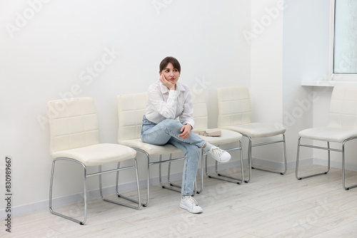 Woman sitting on chair and waiting for job interview indoors
