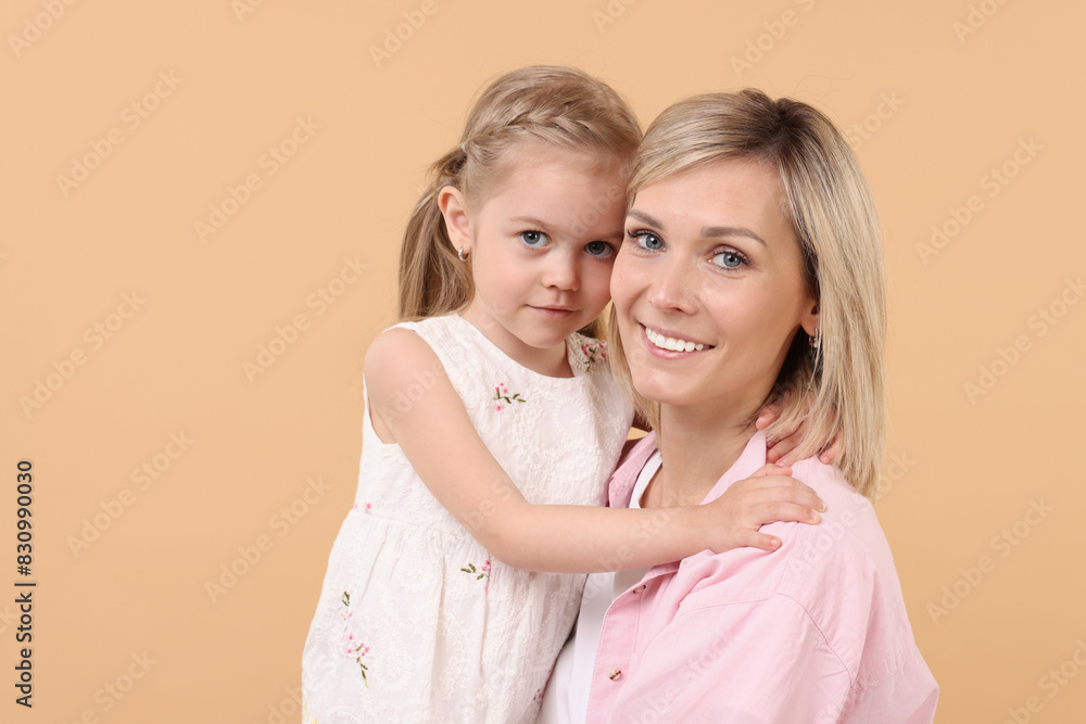 Family portrait of happy mother and daughter on beige background Family portrait of happy mother and daughter on beige background