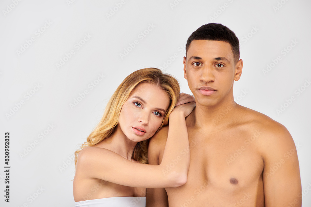 A diverse couple, pose lovingly against a white backdrop. A diverse couple, pose lovingly against a white backdrop.