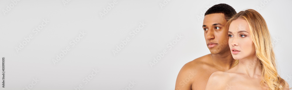 Couple posing together against white backdrop. Couple posing together against white backdrop.