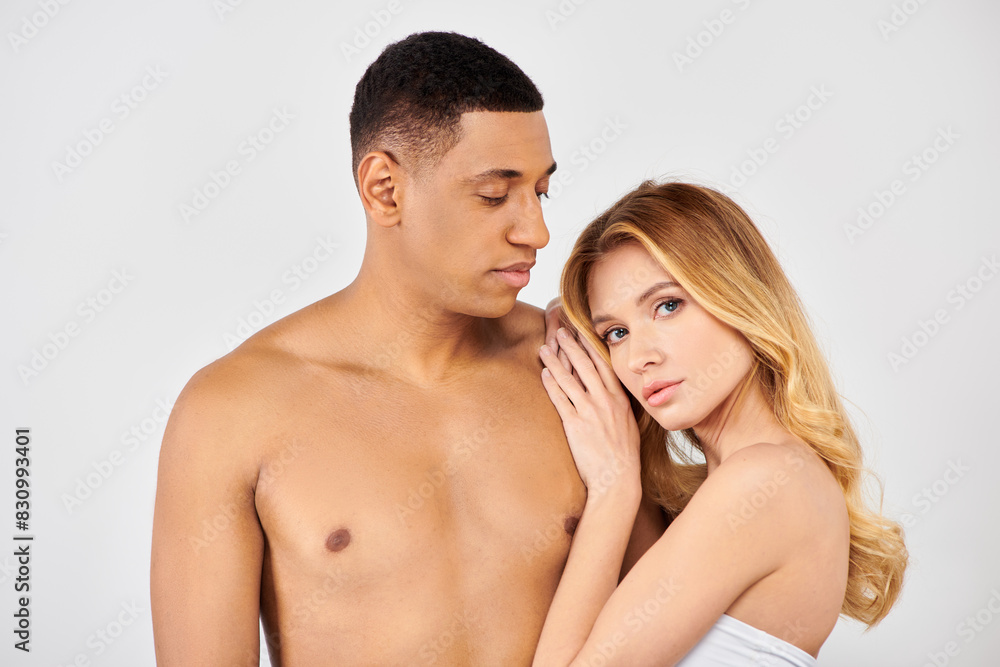 Young man and woman pose together against white backdrop. Young man and woman pose together against white backdrop.