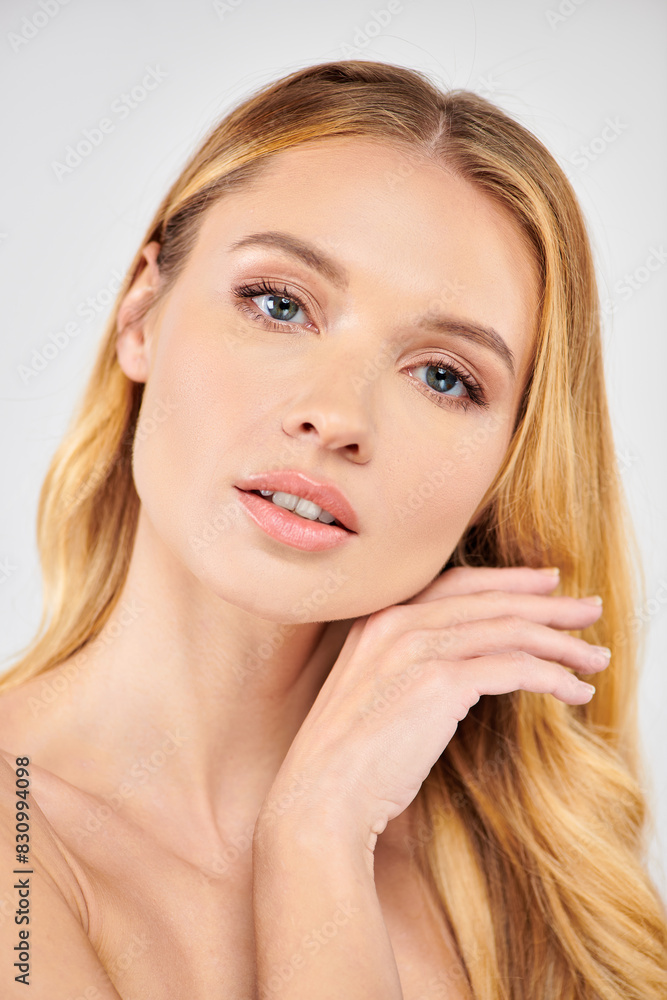Long blonde hair woman poses with hands on face. Long blonde hair woman poses with hands on face.