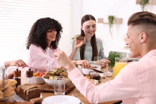 Friends eating vegetarian food at table indoors