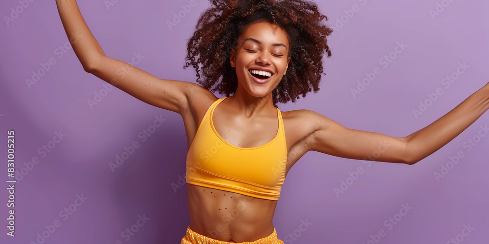 Obraz premium Happy African American woman in yellow top dancing energetically