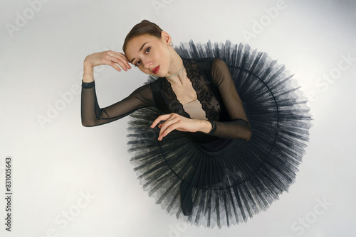 portrait of a young ballerina in a black tutu dancing with her hands moving top view, immersion in dance