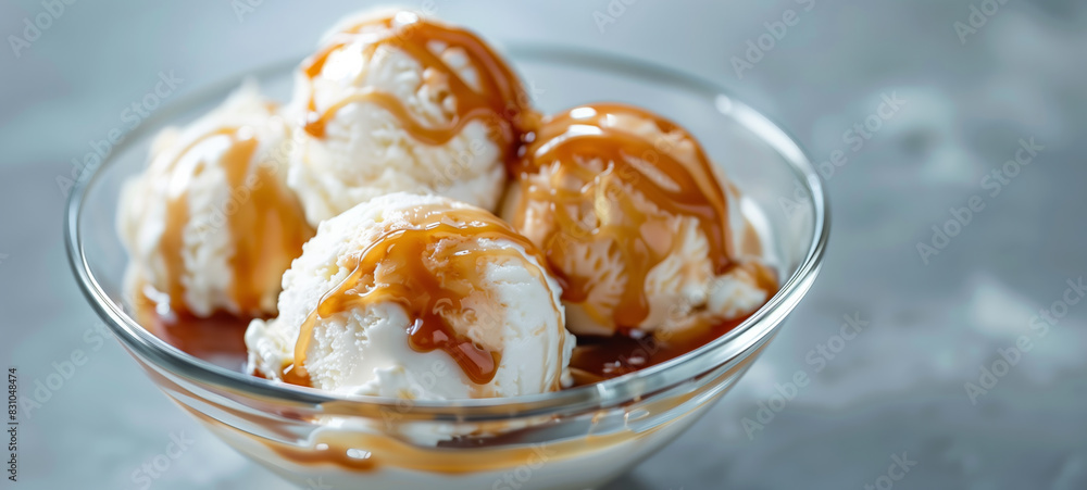 Vanilla Ice Cream with Caramel Topping in a Glass Bowl. Scoops of Vanilla Ice Cream Drizzled with Caramel Sauce Vanilla Ice Cream with Caramel Topping in a Glass Bowl. Scoops of Vanilla Ice Cream Drizzled with Caramel Sauce