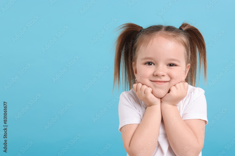 Portrait of cute little girl on light blue background, space for text Portrait of cute little girl on light blue background, space for text