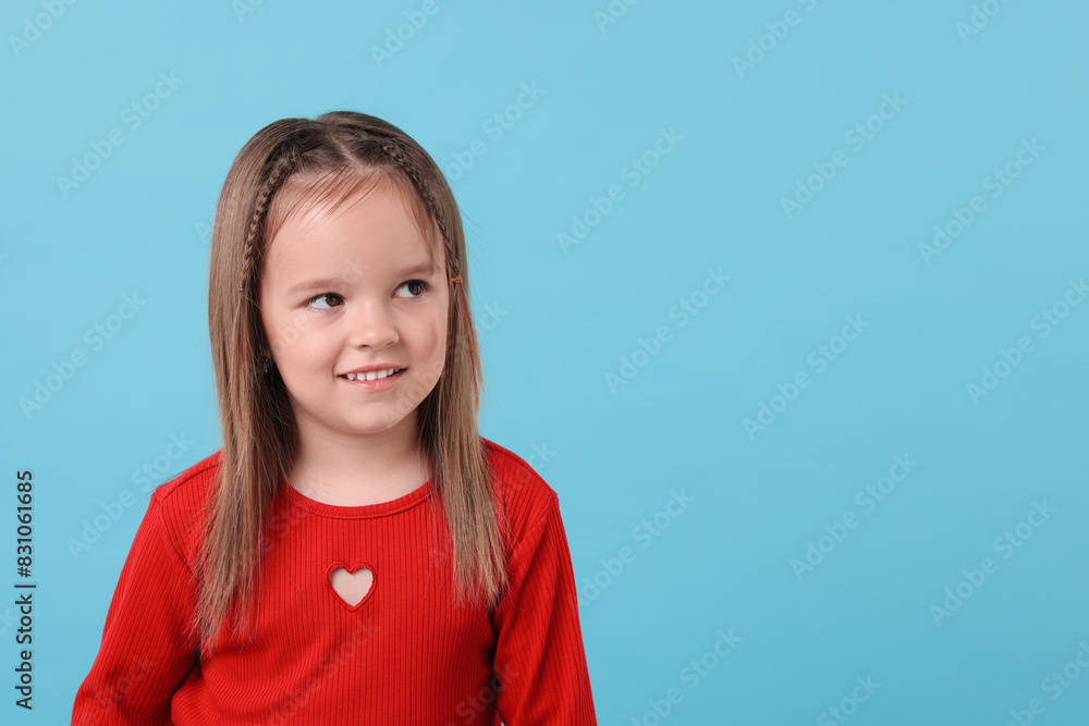 Portrait of happy little girl on light blue background, space for text Portrait of happy little girl on light blue background, space for text