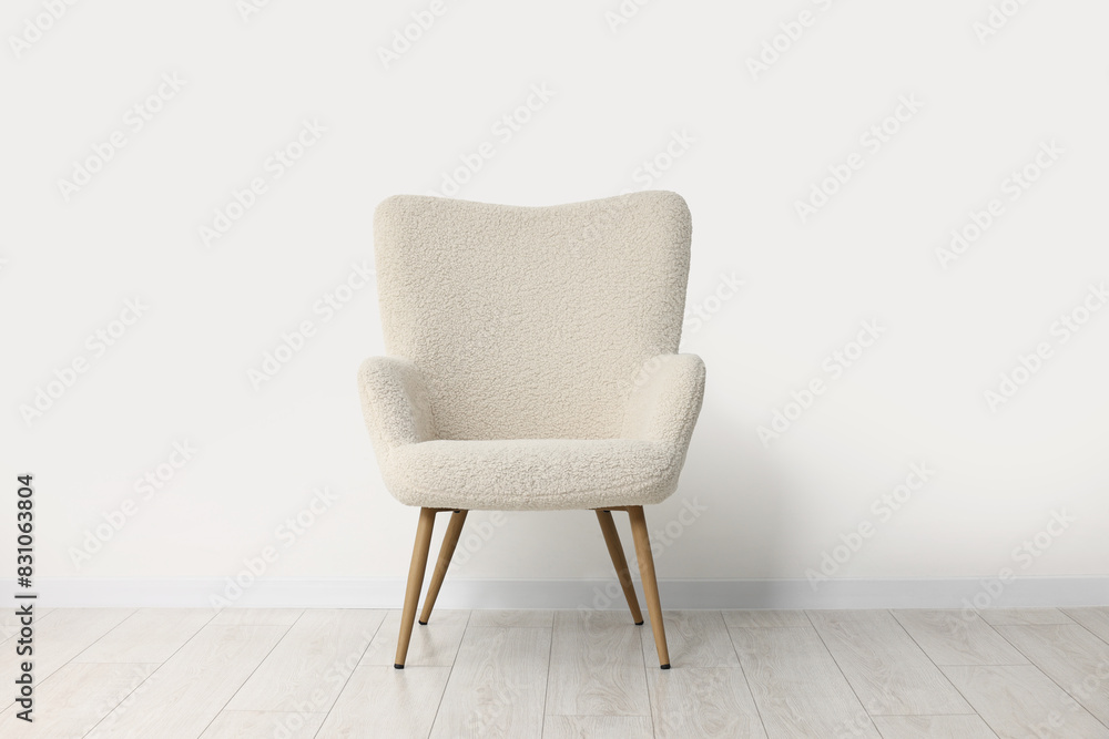 Fototapeta premium Comfortable armchair near white wall in room