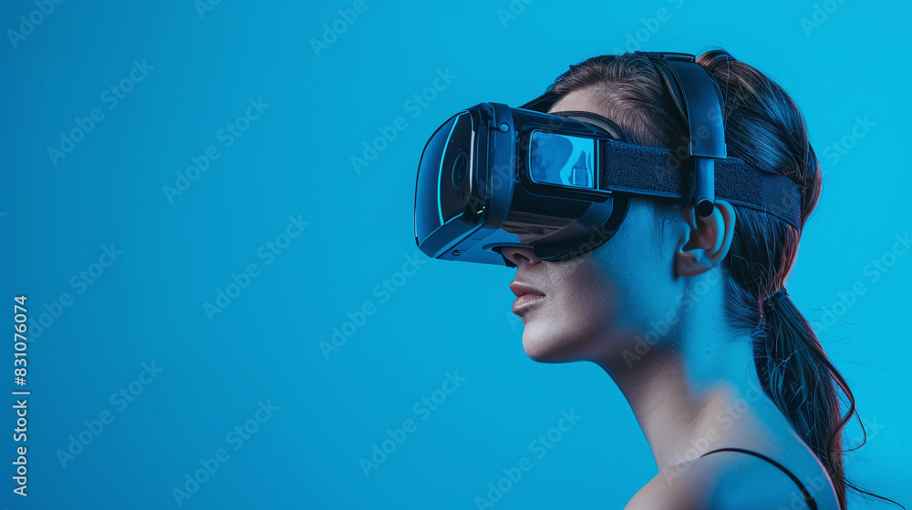 Young Woman Wearing VR Headset Immersed in Virtual Reality with Blue Background and Dark Hair Young Woman Wearing VR Headset Immersed in Virtual Reality with Blue Background and Dark Hair
