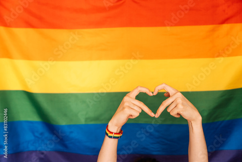 Hands showing heart and love against LGBT flag. photo